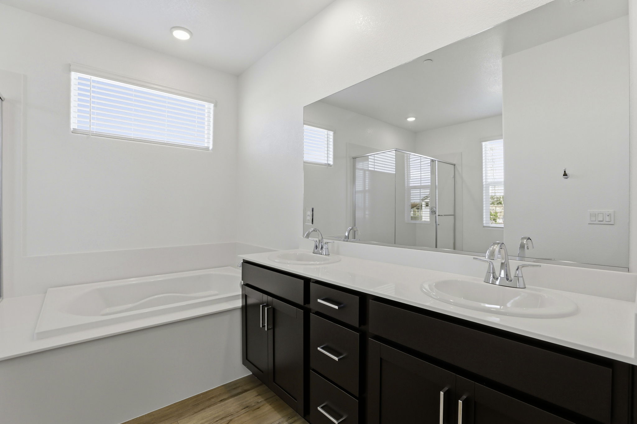 A bathroom with a tub sink and a mirror.