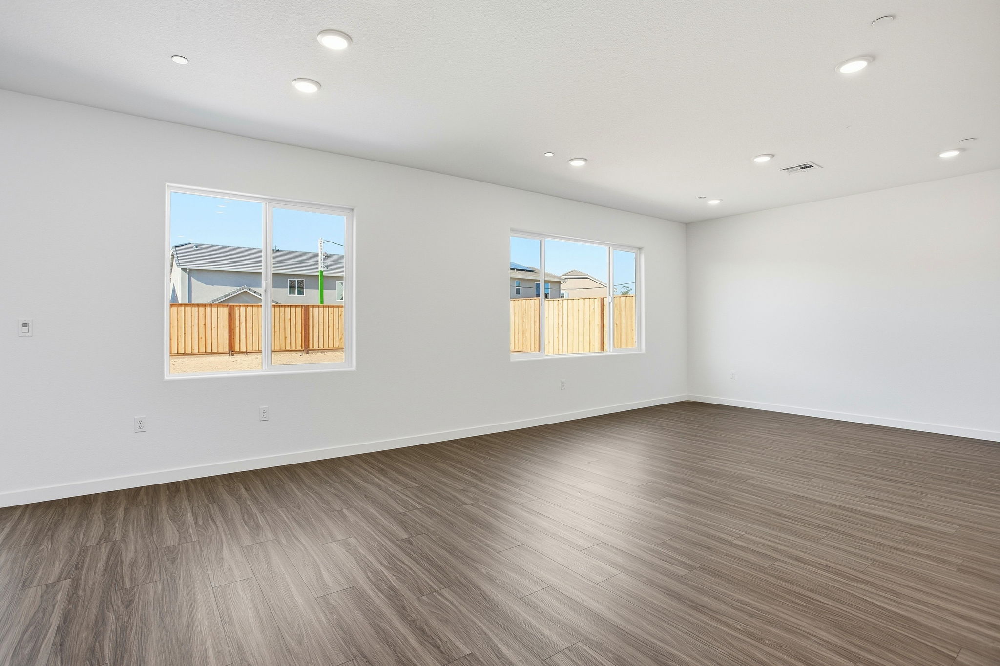 A room with a wood floor and a wood floor with a window.