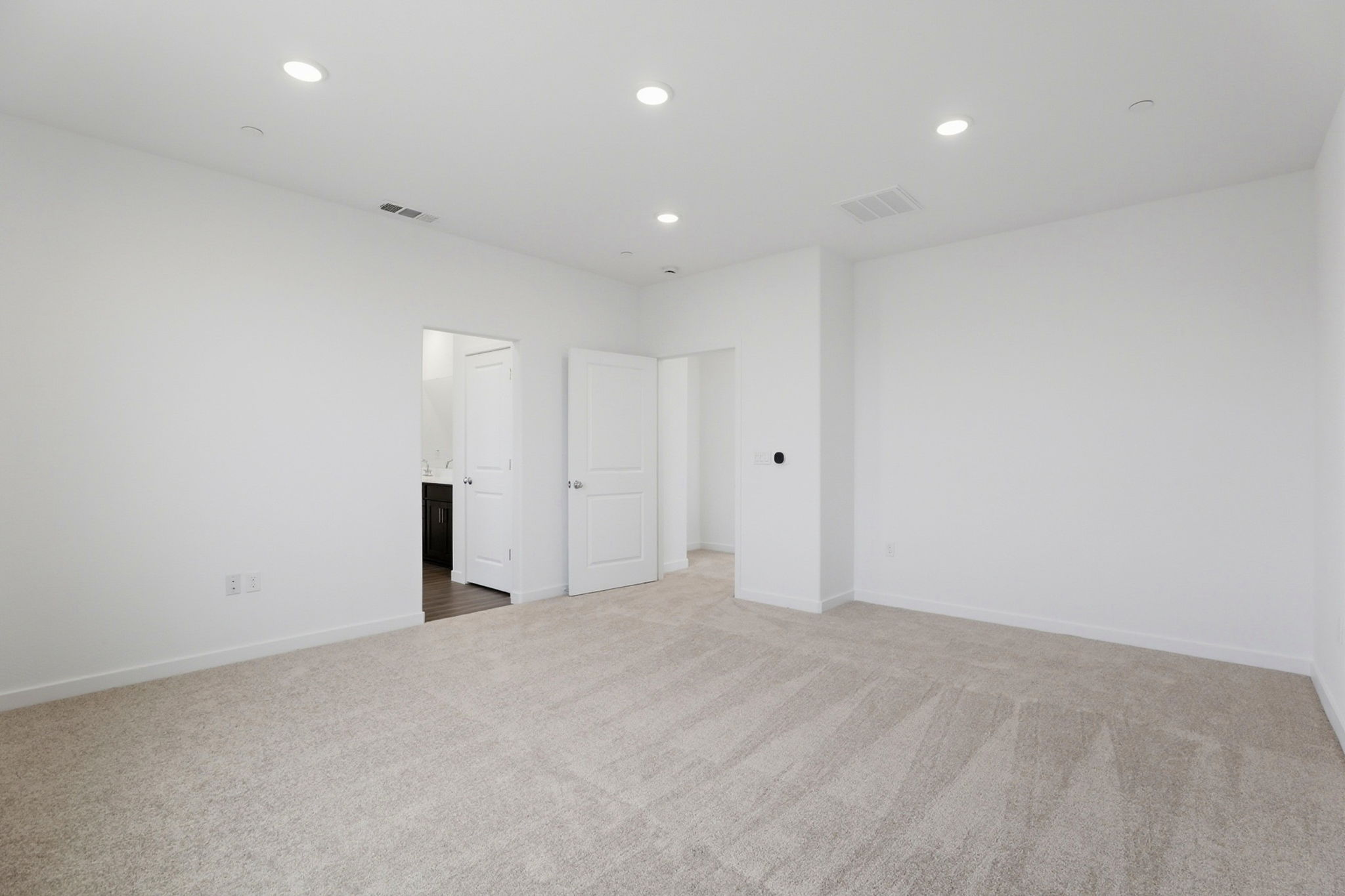 A long hallway with white doors.