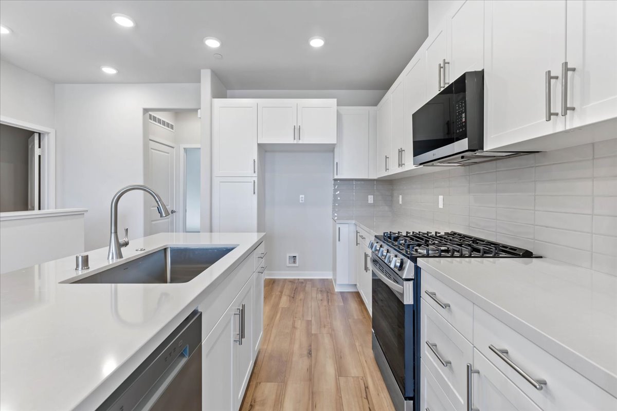 A kitchen with white cabinets.