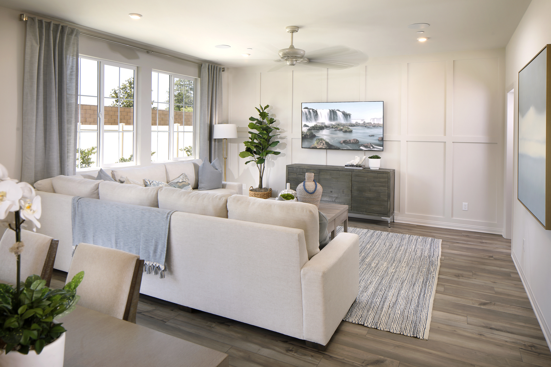 A living room with a large white couch and a fireplace.