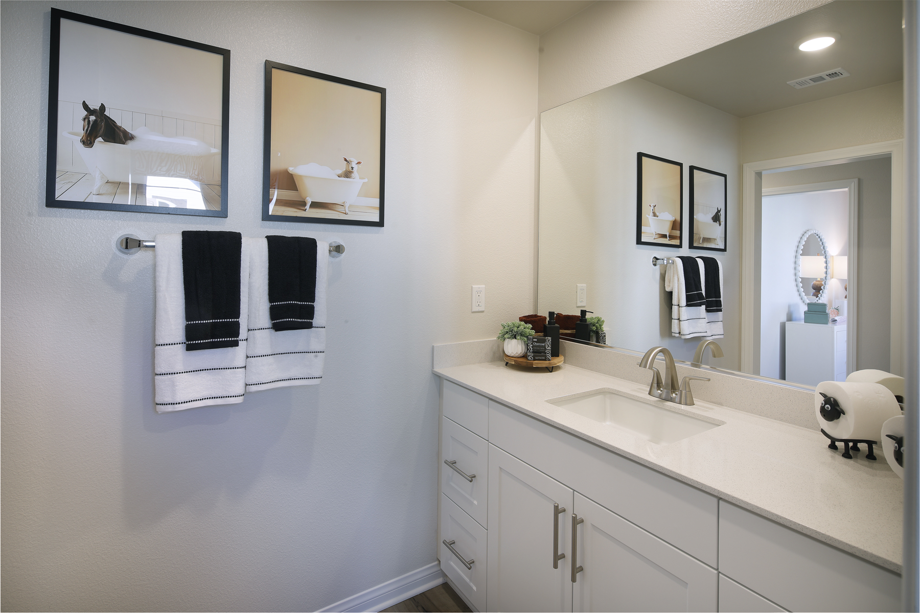 A bathroom with white cabinets.