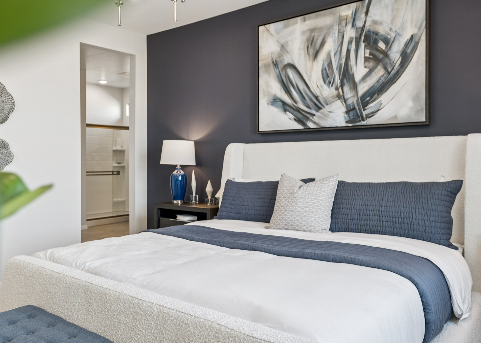 A bed with a blue and white comforter.