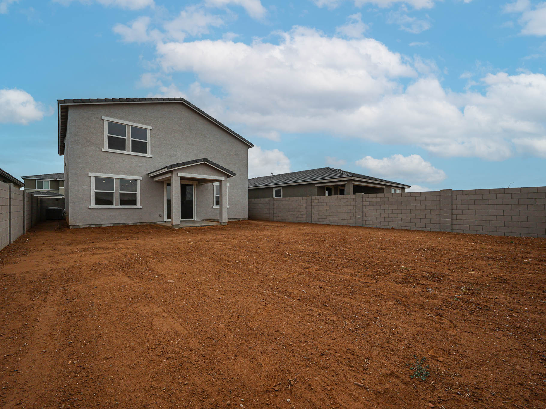 A dirt field with a building in the background.