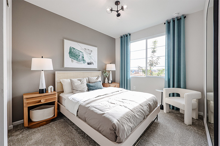 A bedroom with a bed and a chair.