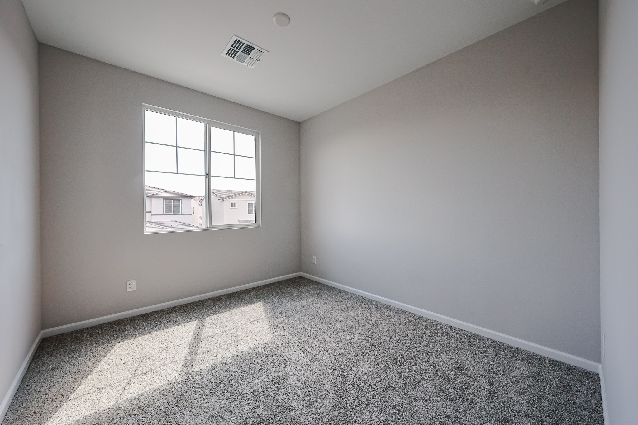 A room with a window and a carpet.