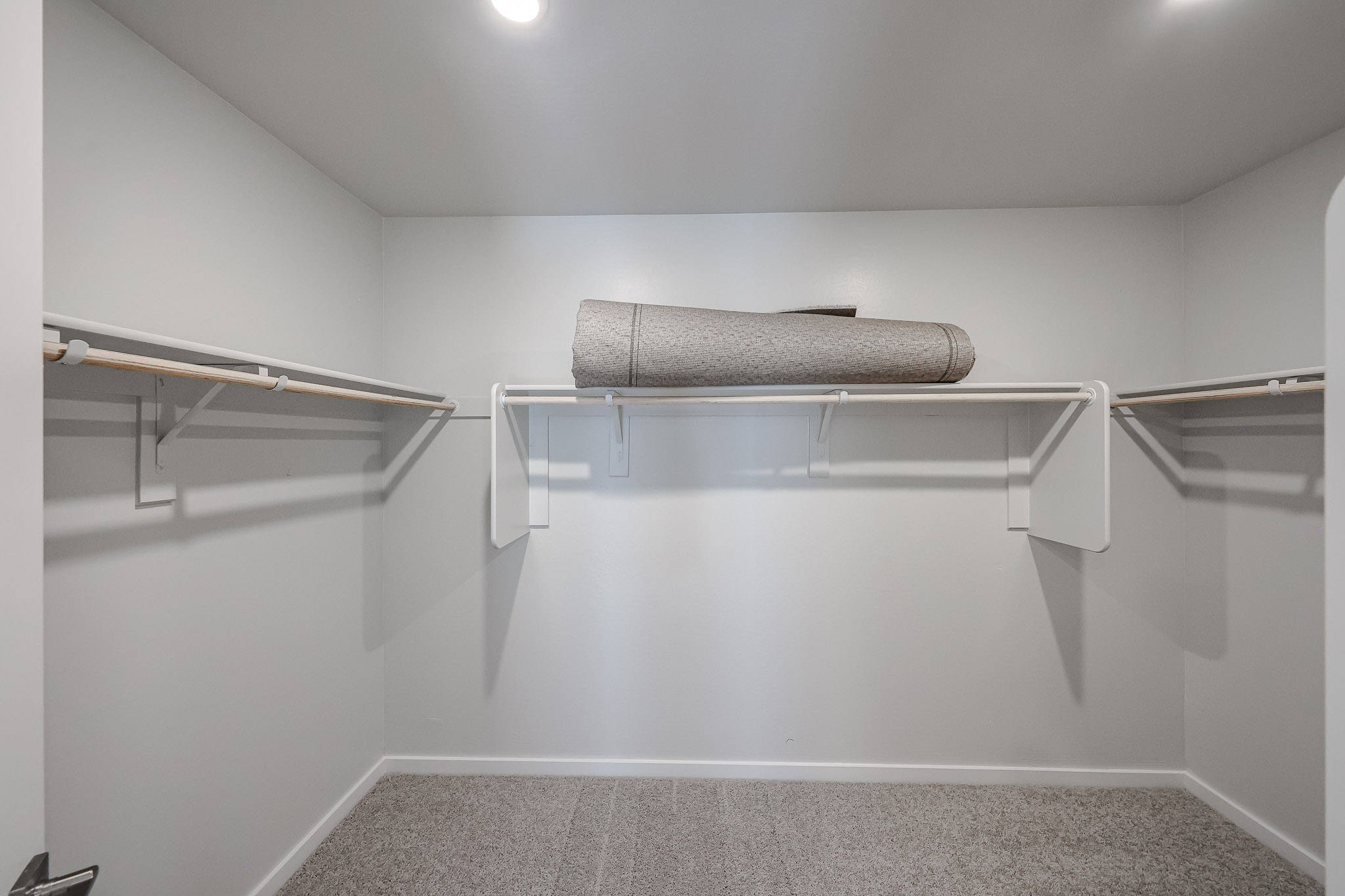 A white shelf with a towel on it.