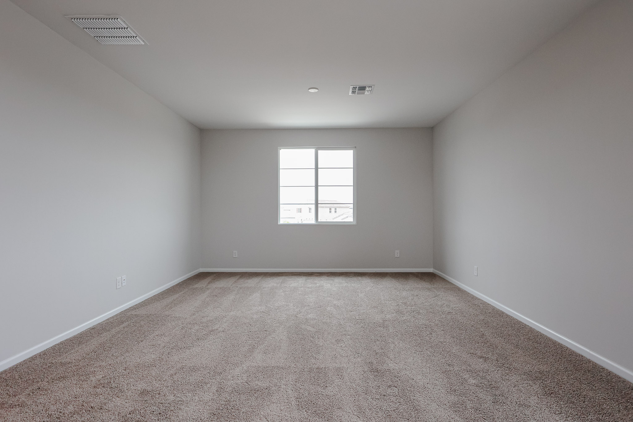 A room with a carpet and a window.