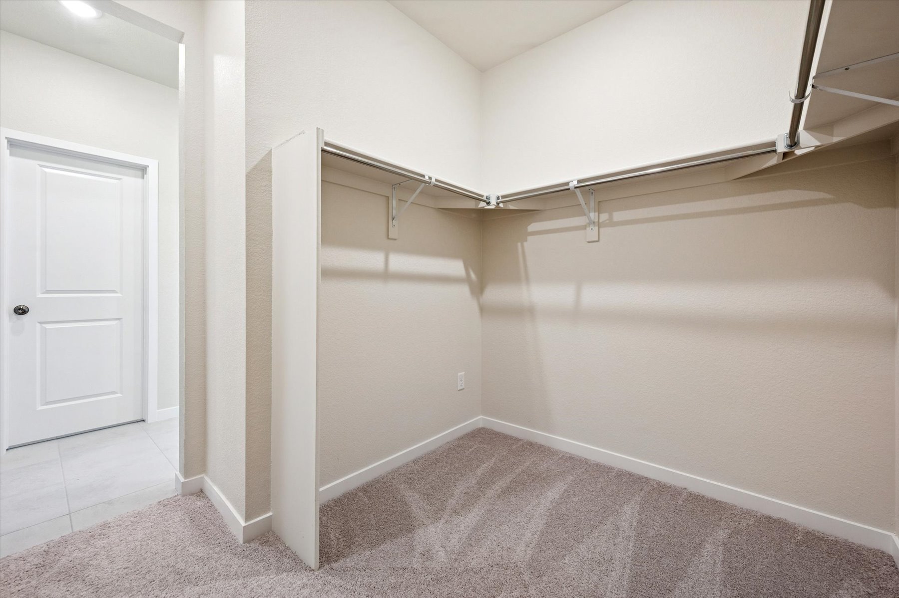 A room with a carpet and a white door.