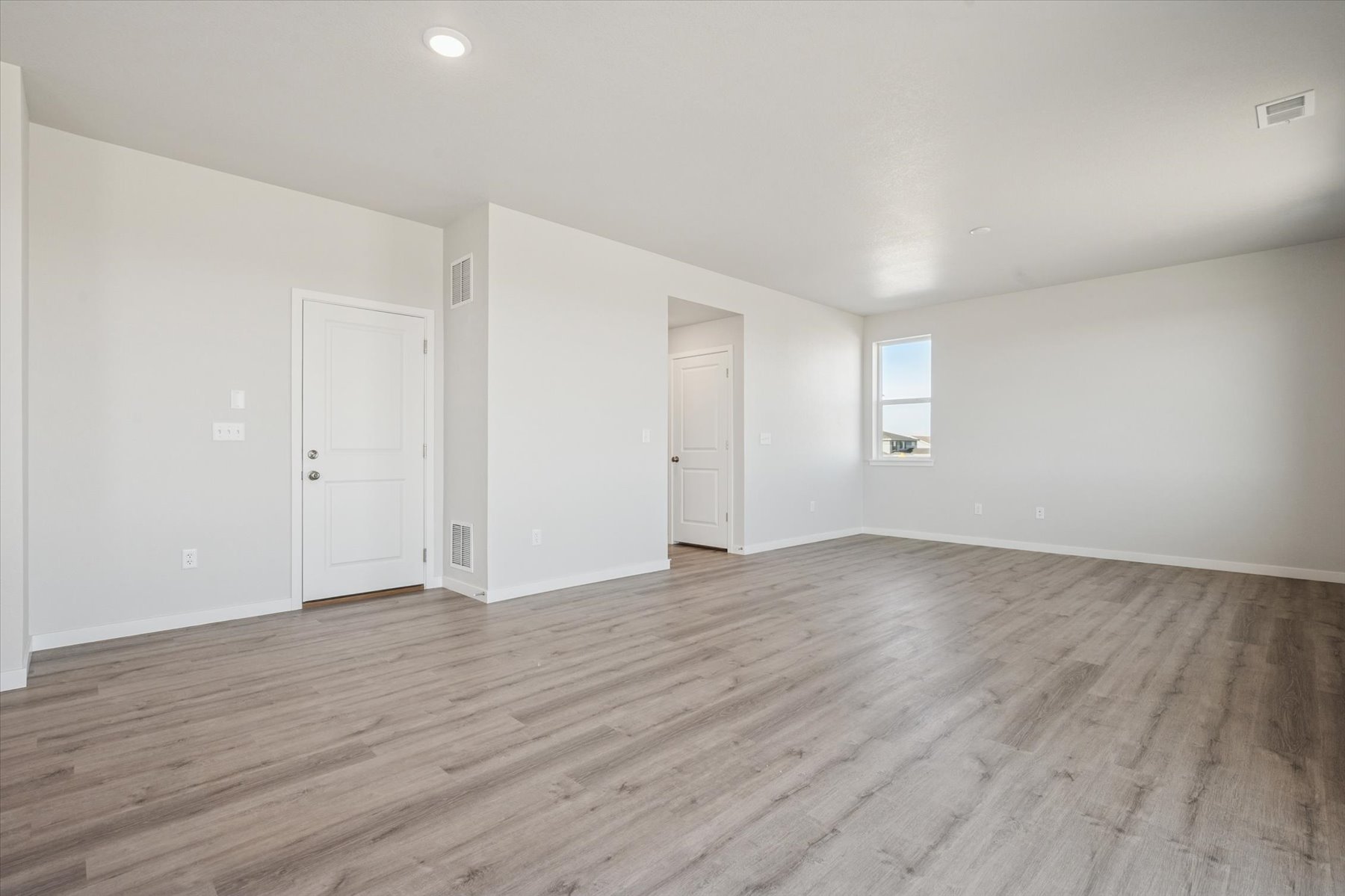 A room with white walls and wood floors.