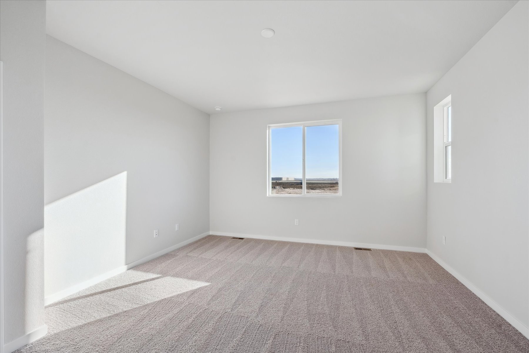 A room with a window and carpet.