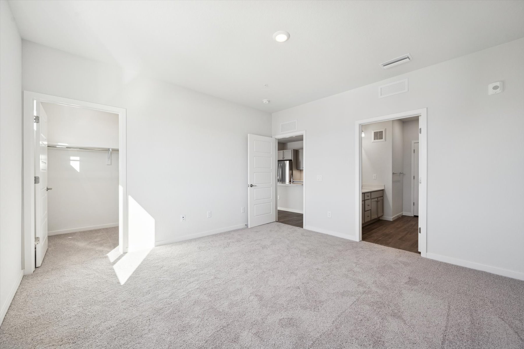 A long hallway with white doors.