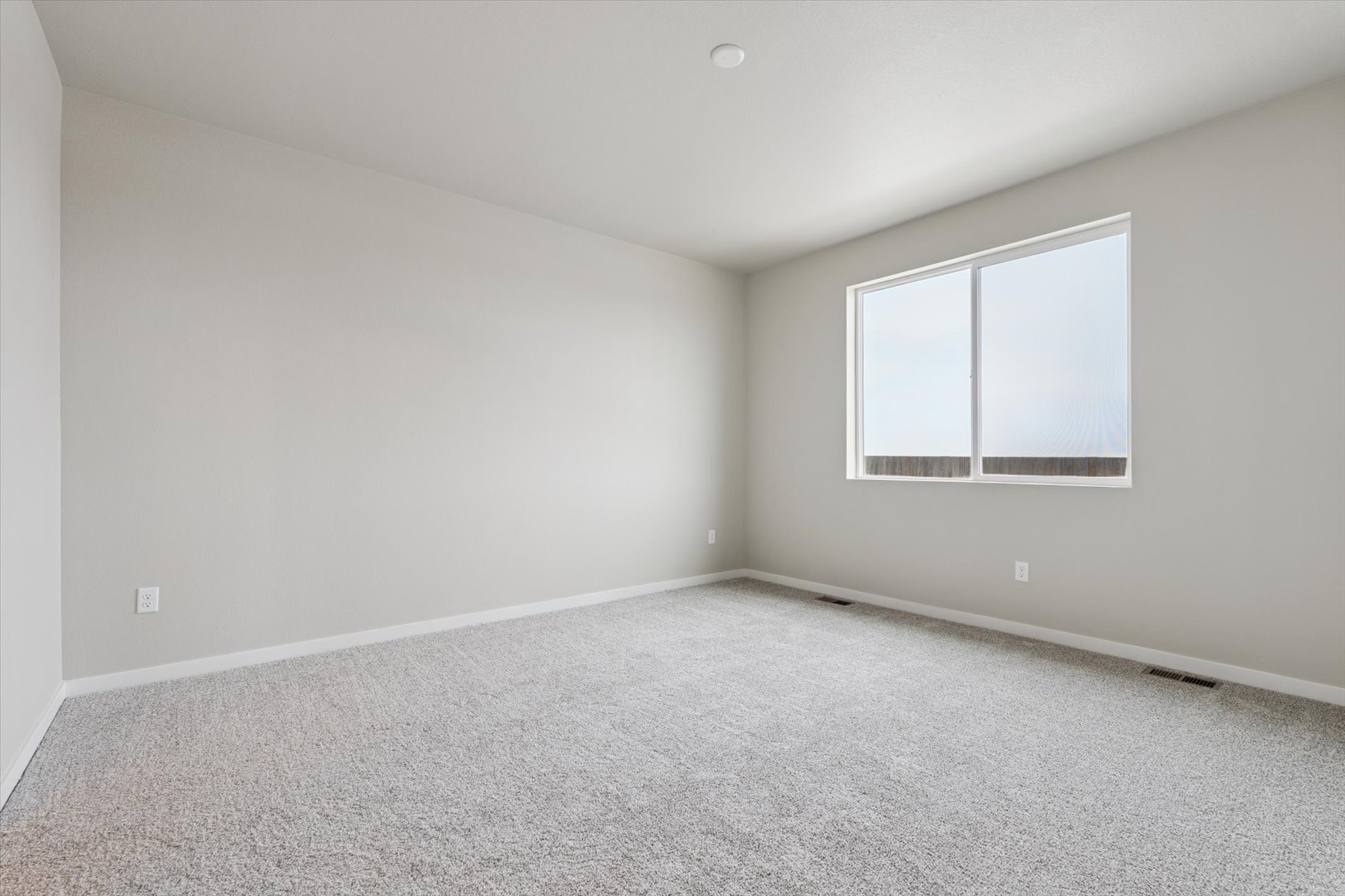 A room with a window and carpet.
