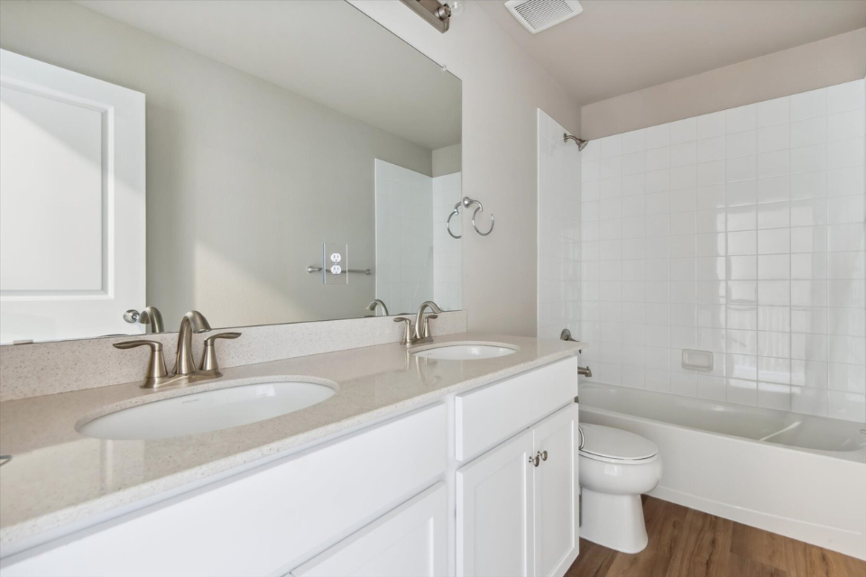 A bathroom with a tub sink and toilet.