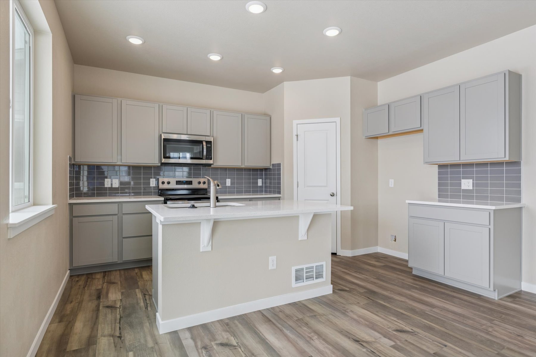 A kitchen with white cabinets.