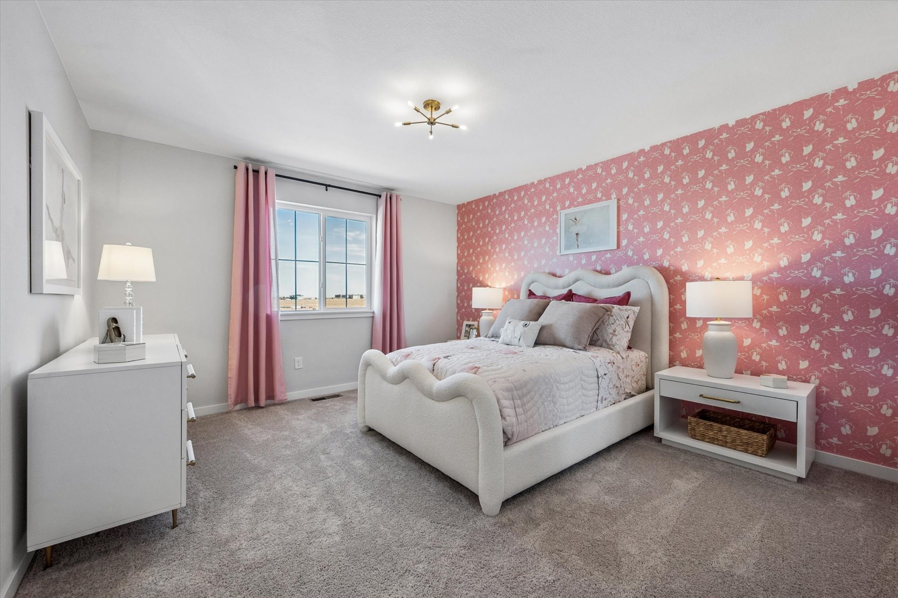 A bedroom with pink curtains.