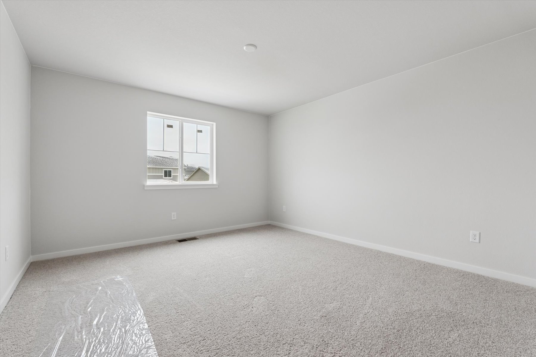 A room with a window and carpet.