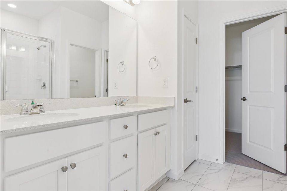 A bathroom with white cabinets.