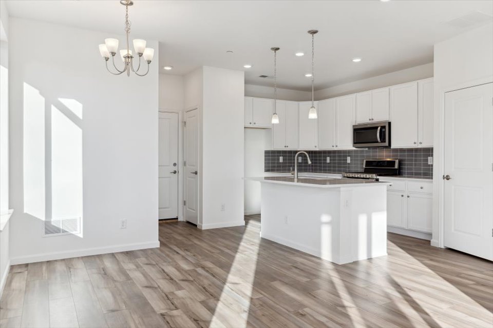 A kitchen with white cabinets.