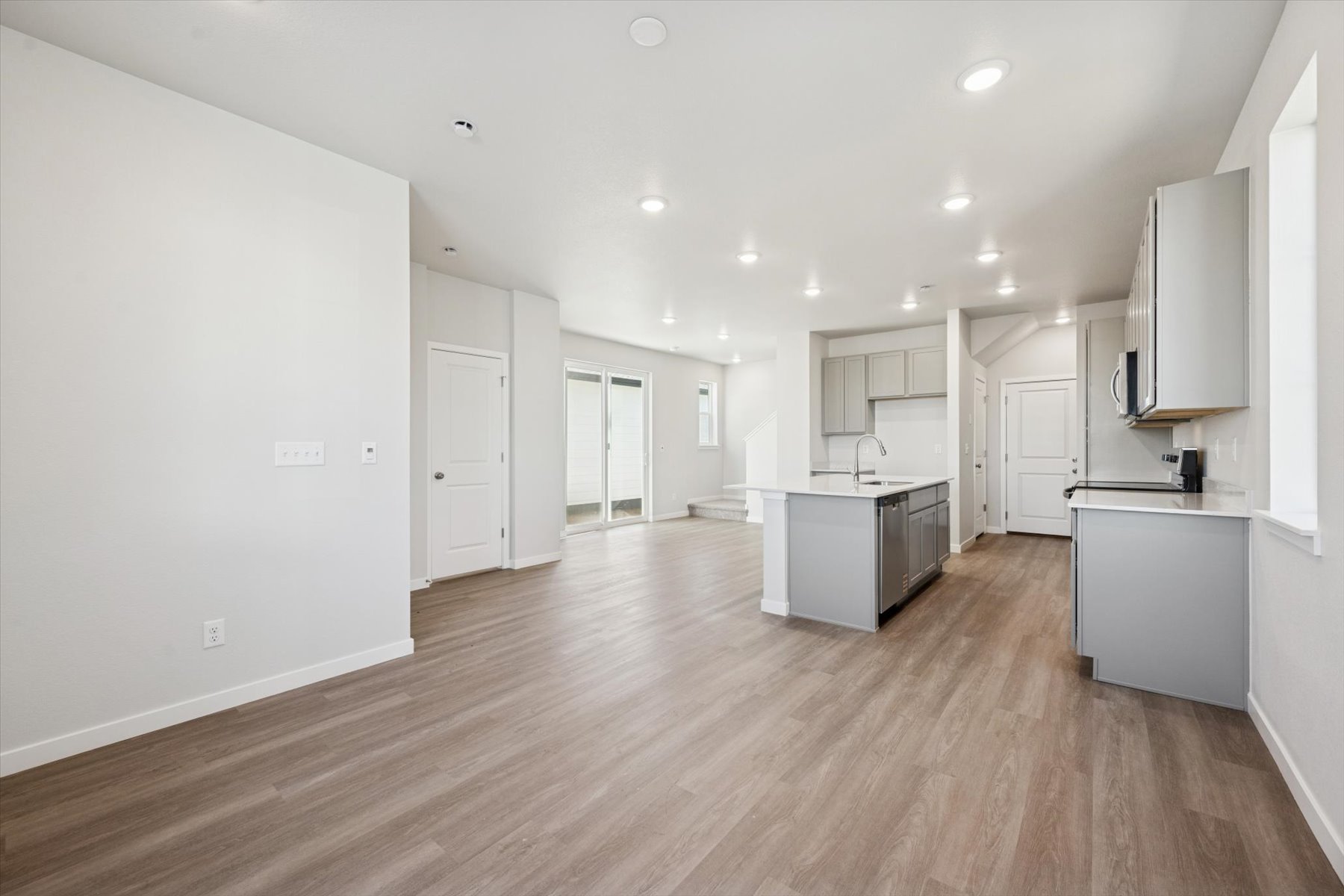A large empty room with white cabinets.