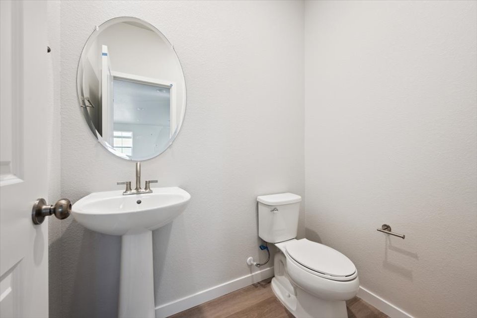 A bathroom with a round mirror.