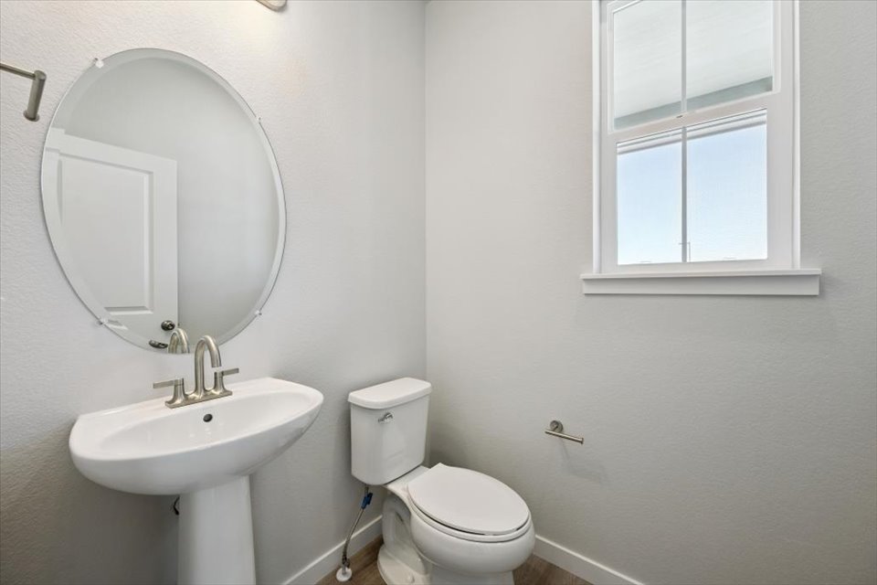 A bathroom with a round mirror.