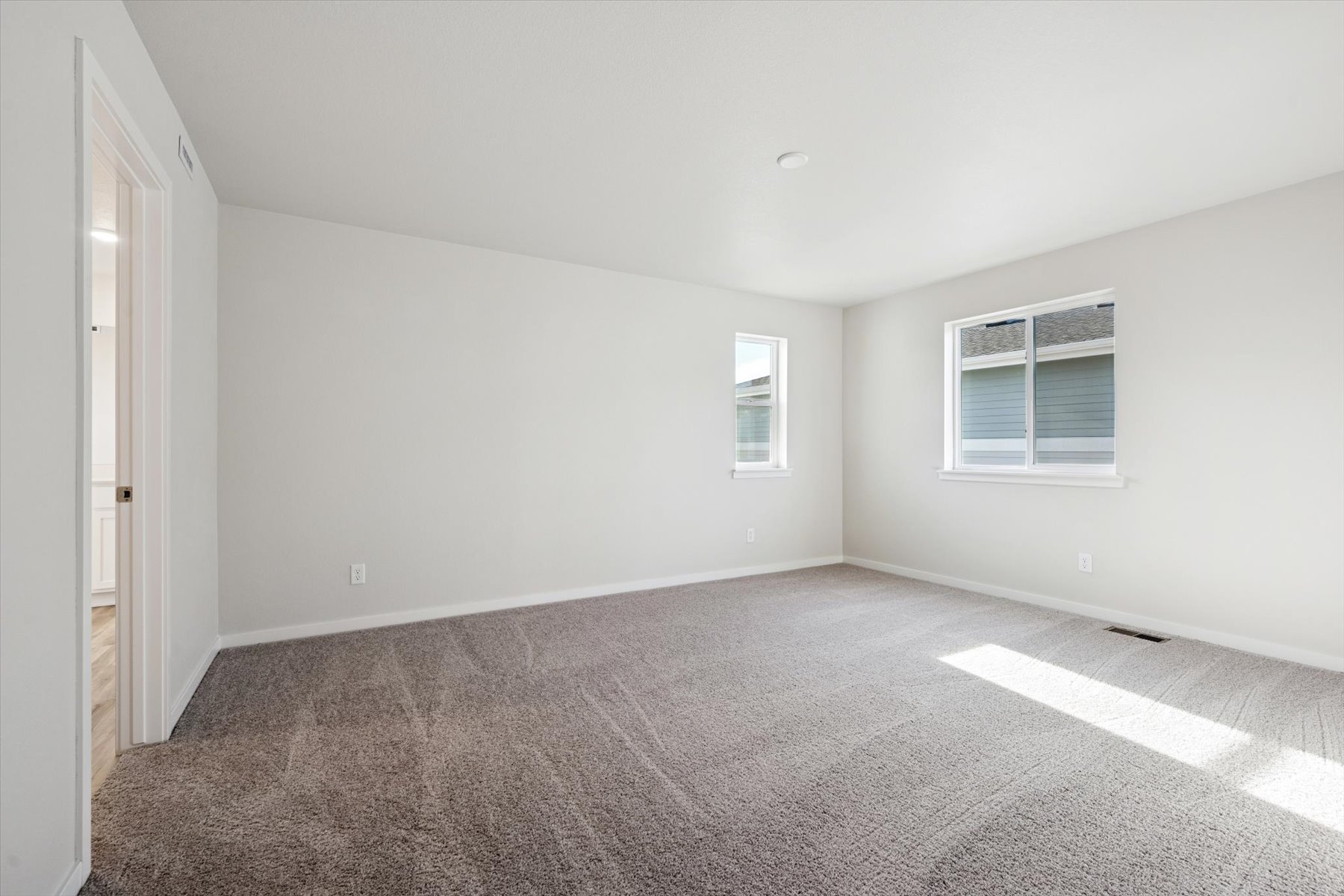 A room with a carpet and windows.