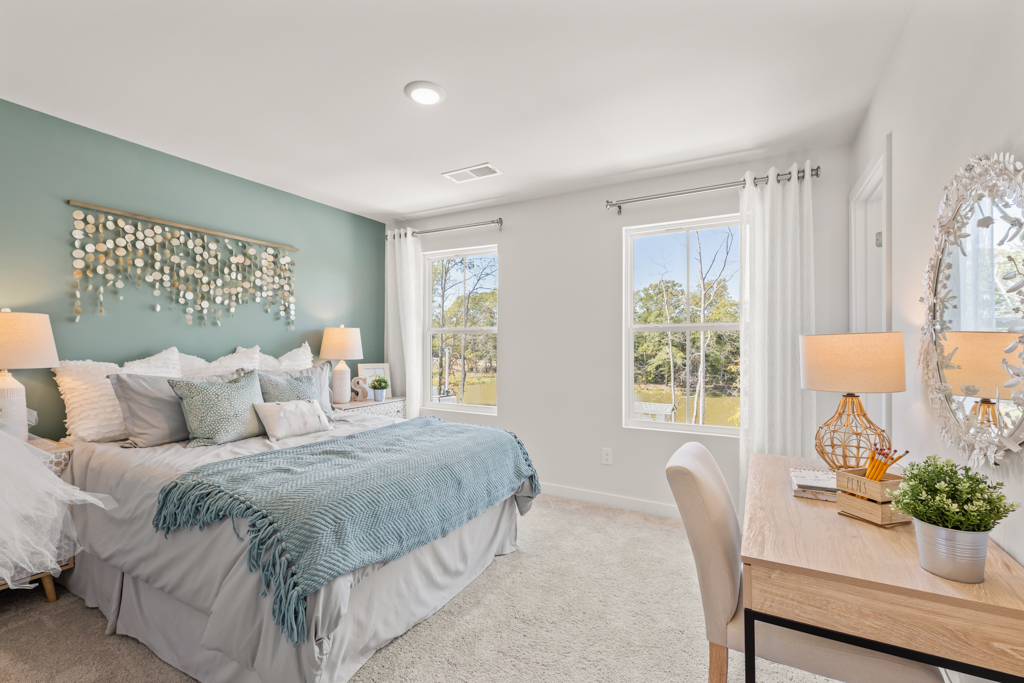 A bedroom with a bed and a table.