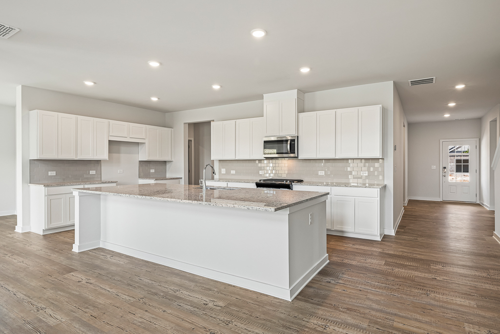 A kitchen with white cabinets.