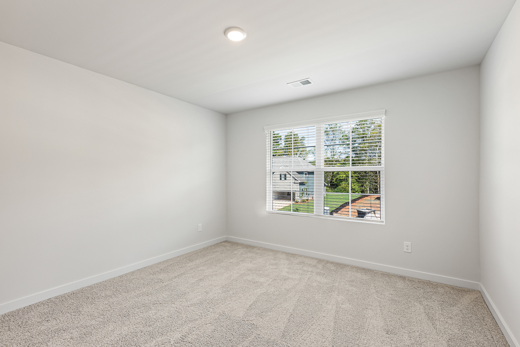 A room with a window and a carpet.