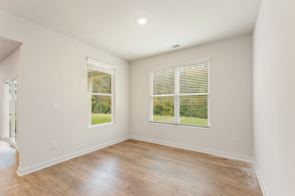A room with a wood floor and windows.