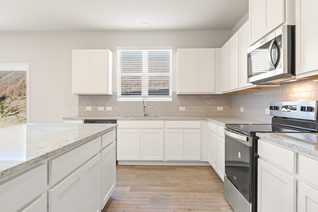 A kitchen with white cabinets.