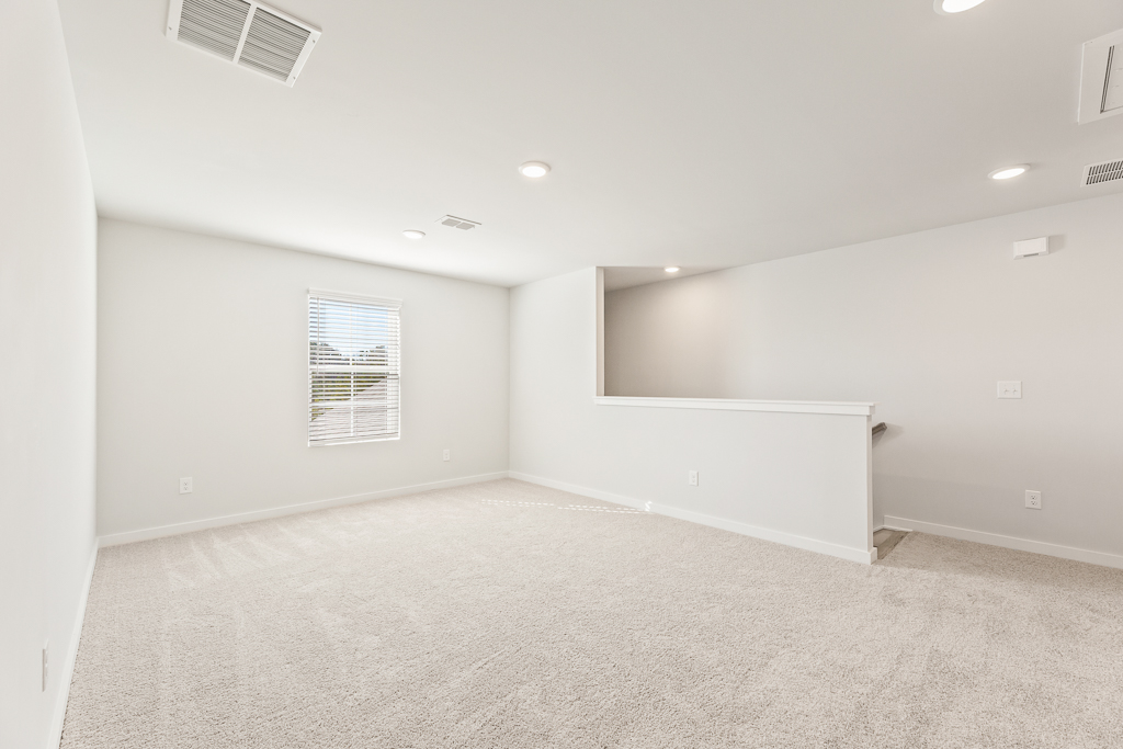 A room with a white wall and a window.