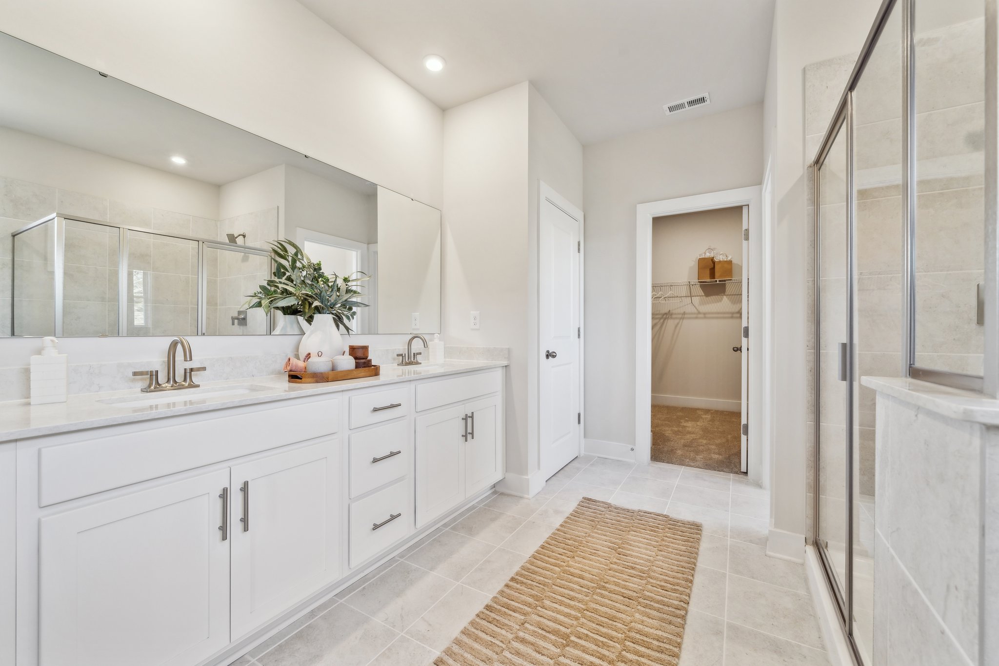 A bathroom with white cabinets.