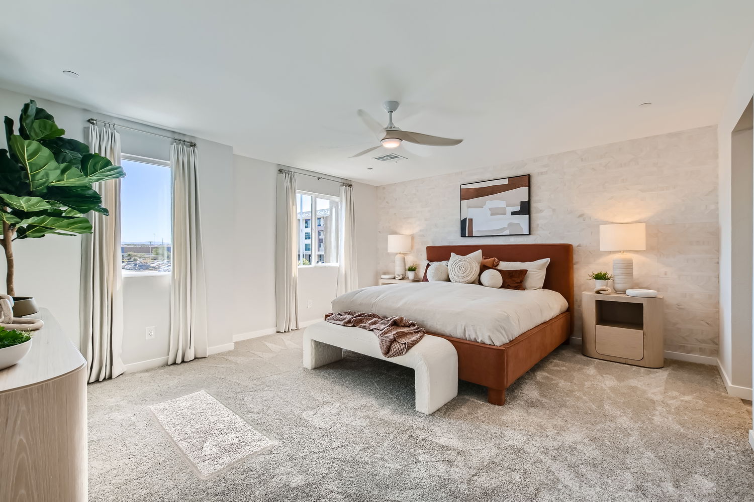 A bedroom with a bed and a bench.