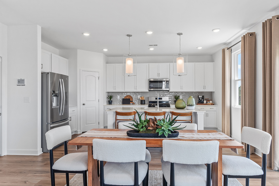 A kitchen with a dining table and chairs.