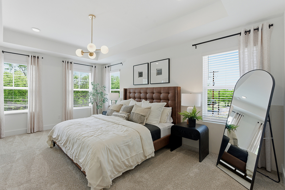 A bedroom with a large mirror.