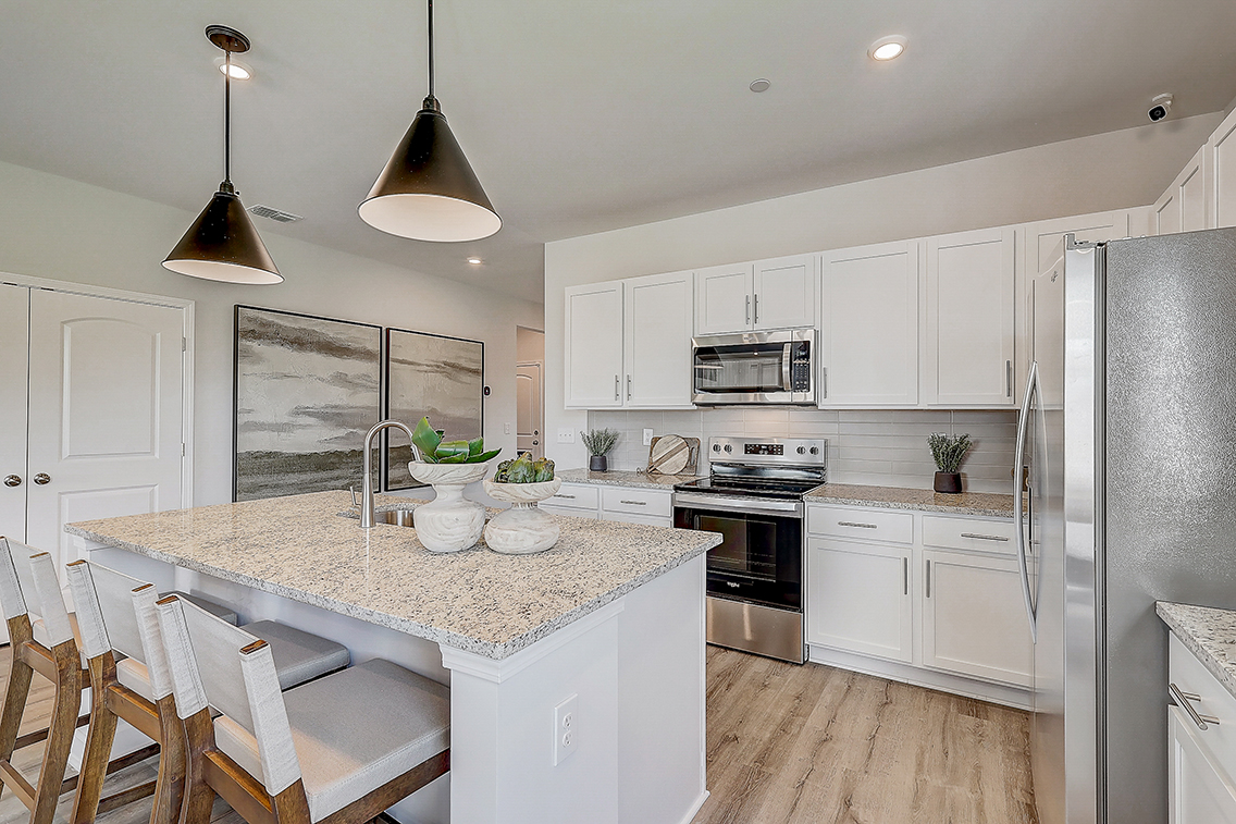 A kitchen with white cabinets.