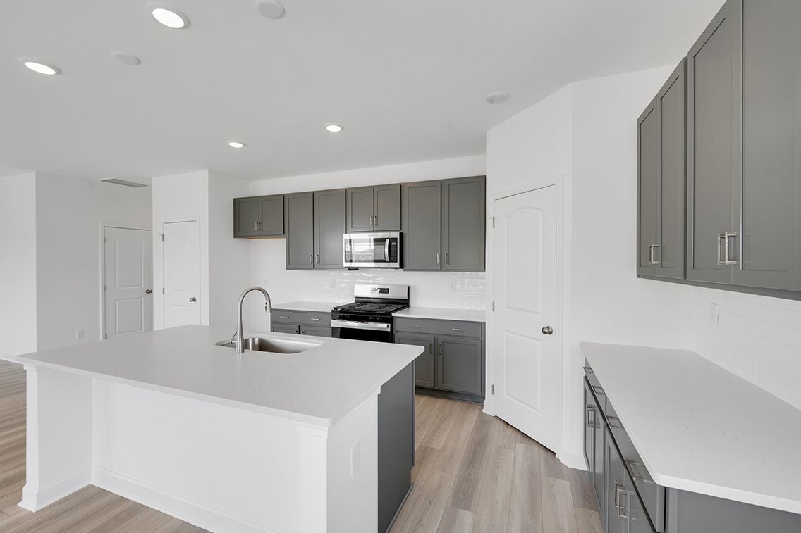 A kitchen with white cabinets.