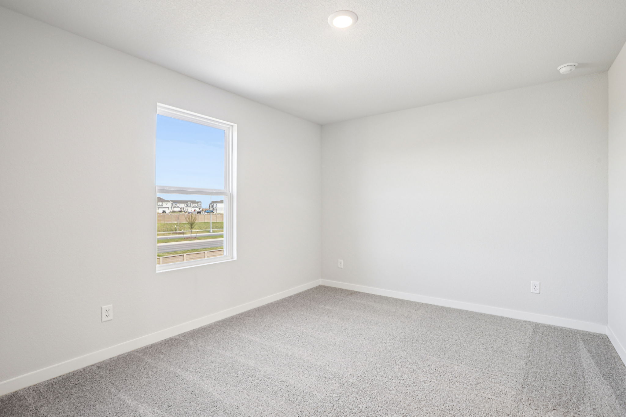 A room with a window and a white wall.