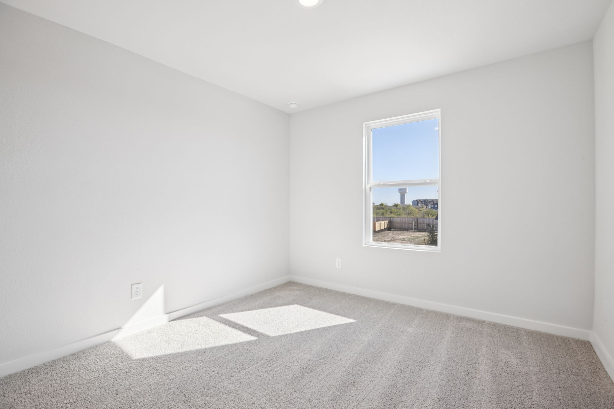 A room with a window and a rug.