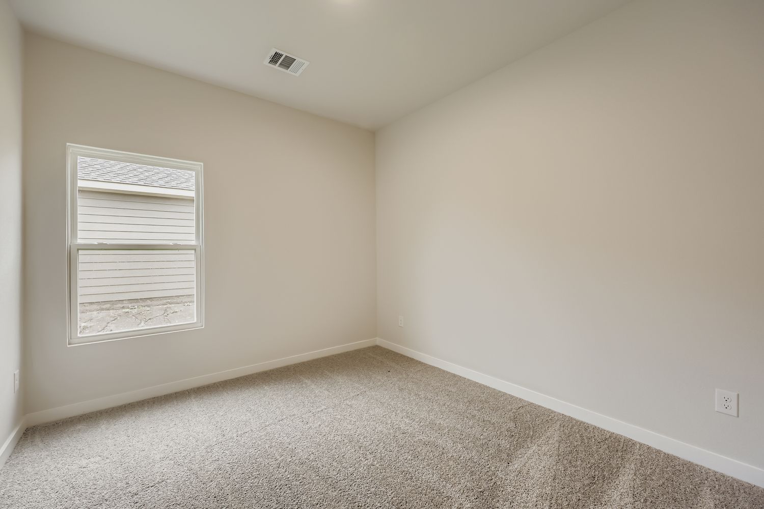 A room with a window and carpet.