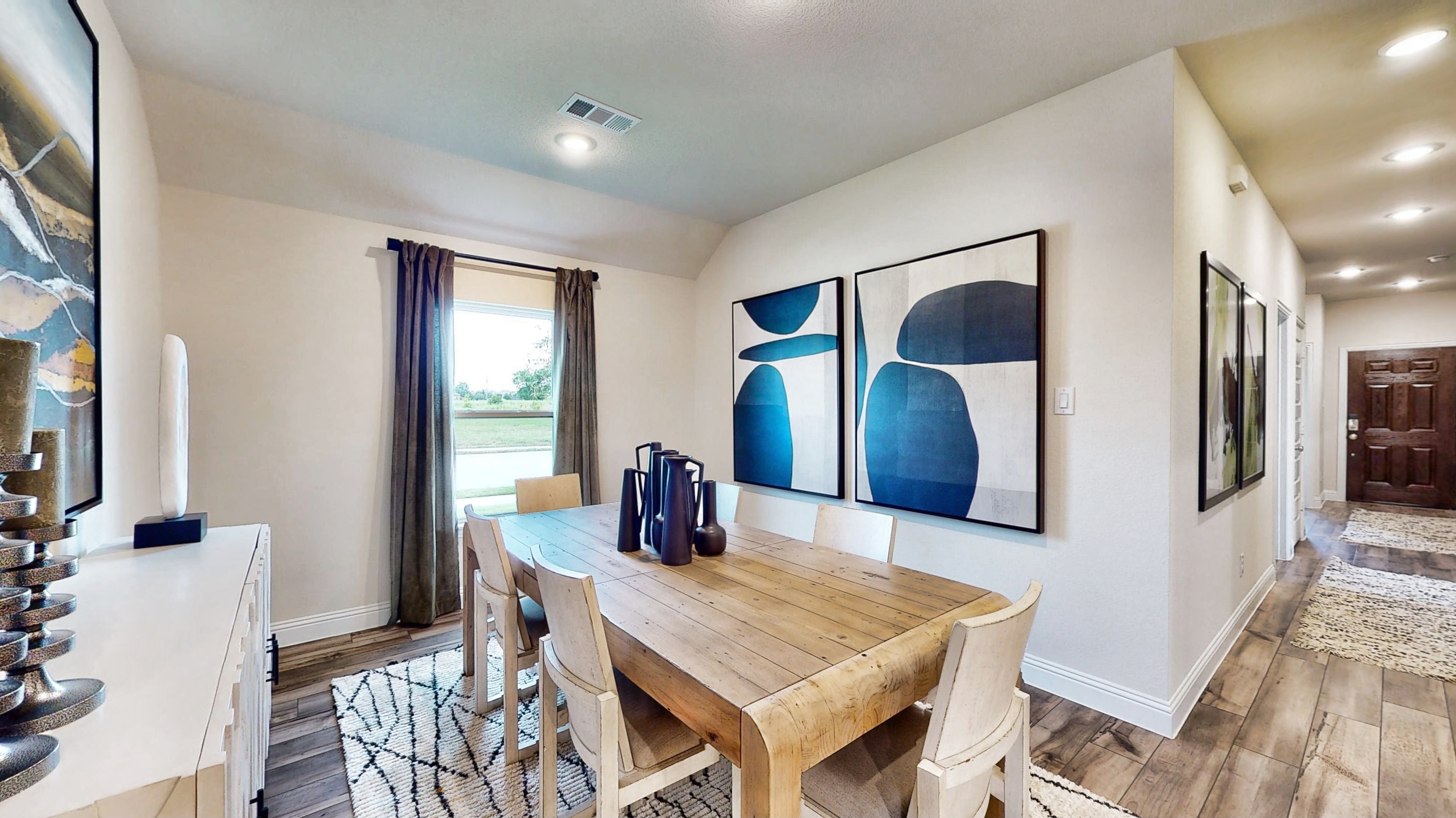 A dining room with a table and chairs.