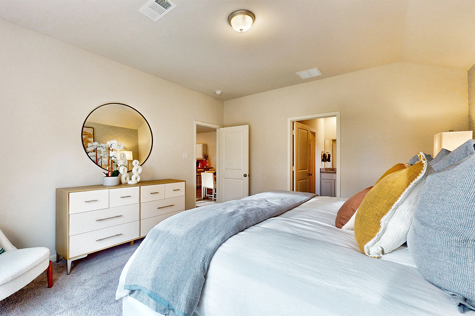 A bedroom with a bed and a mirror.