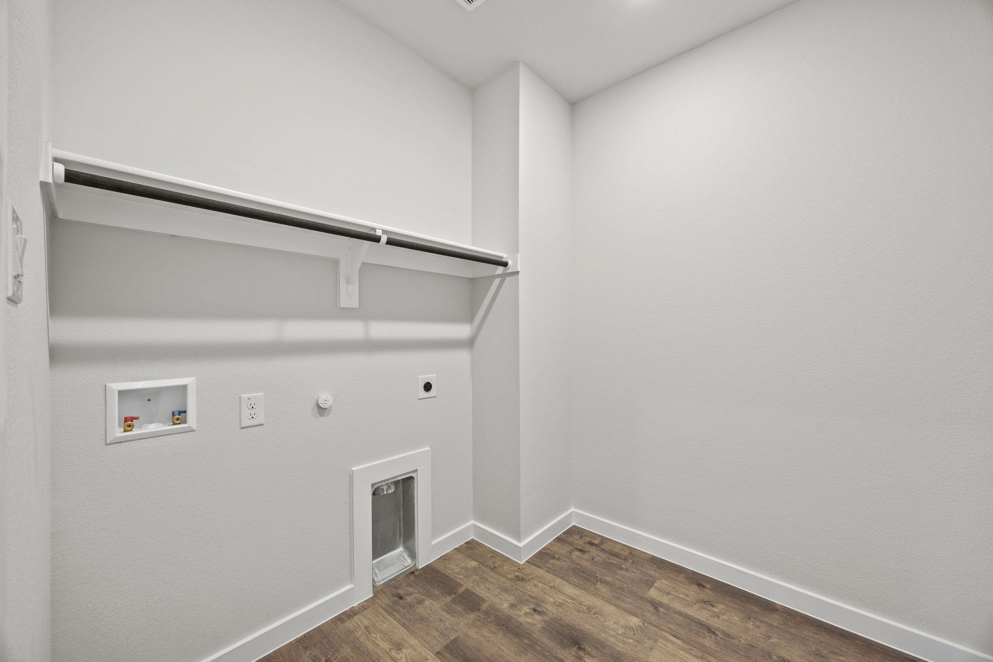 A white room with a wood floor.