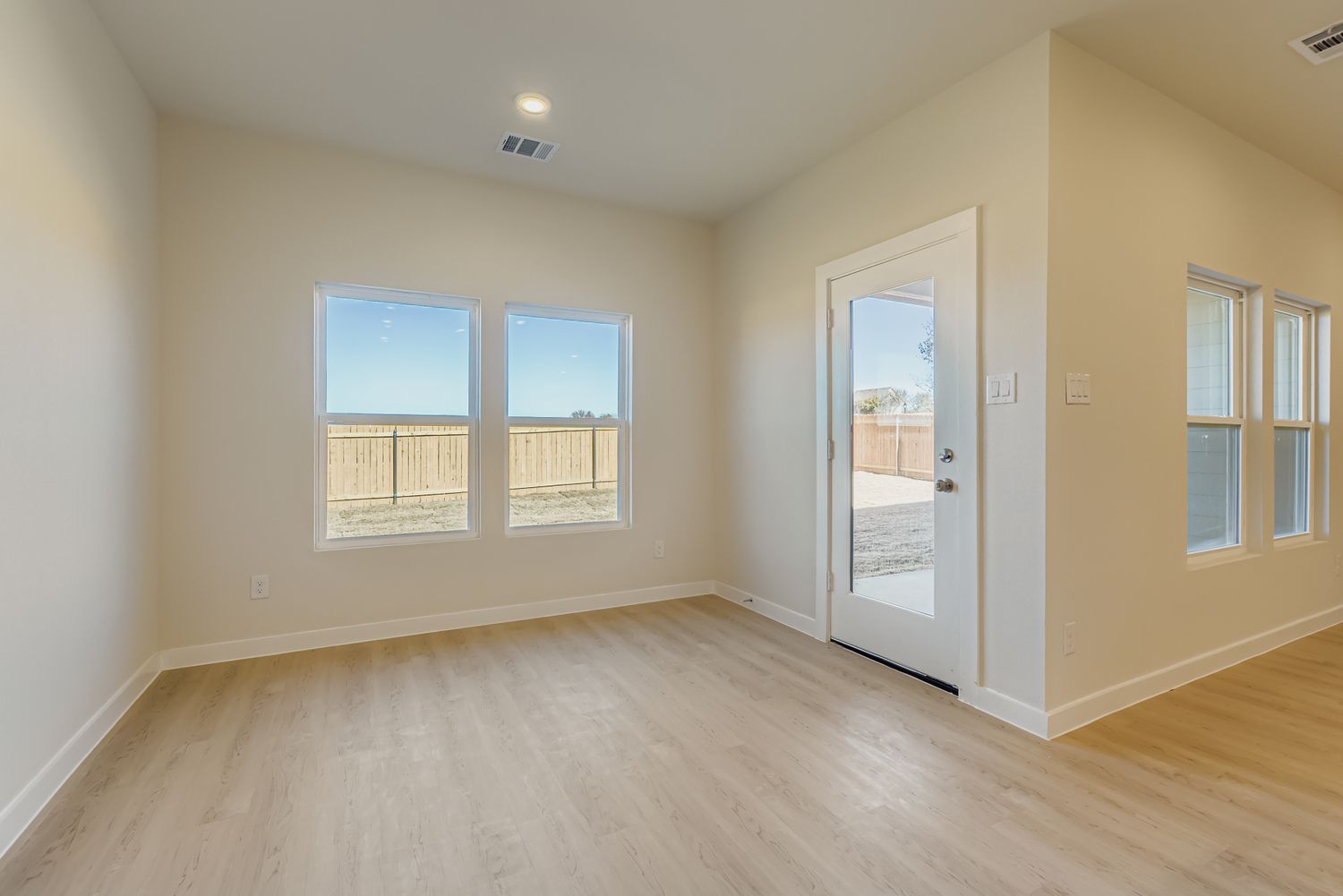 A room with a wood floor and windows.
