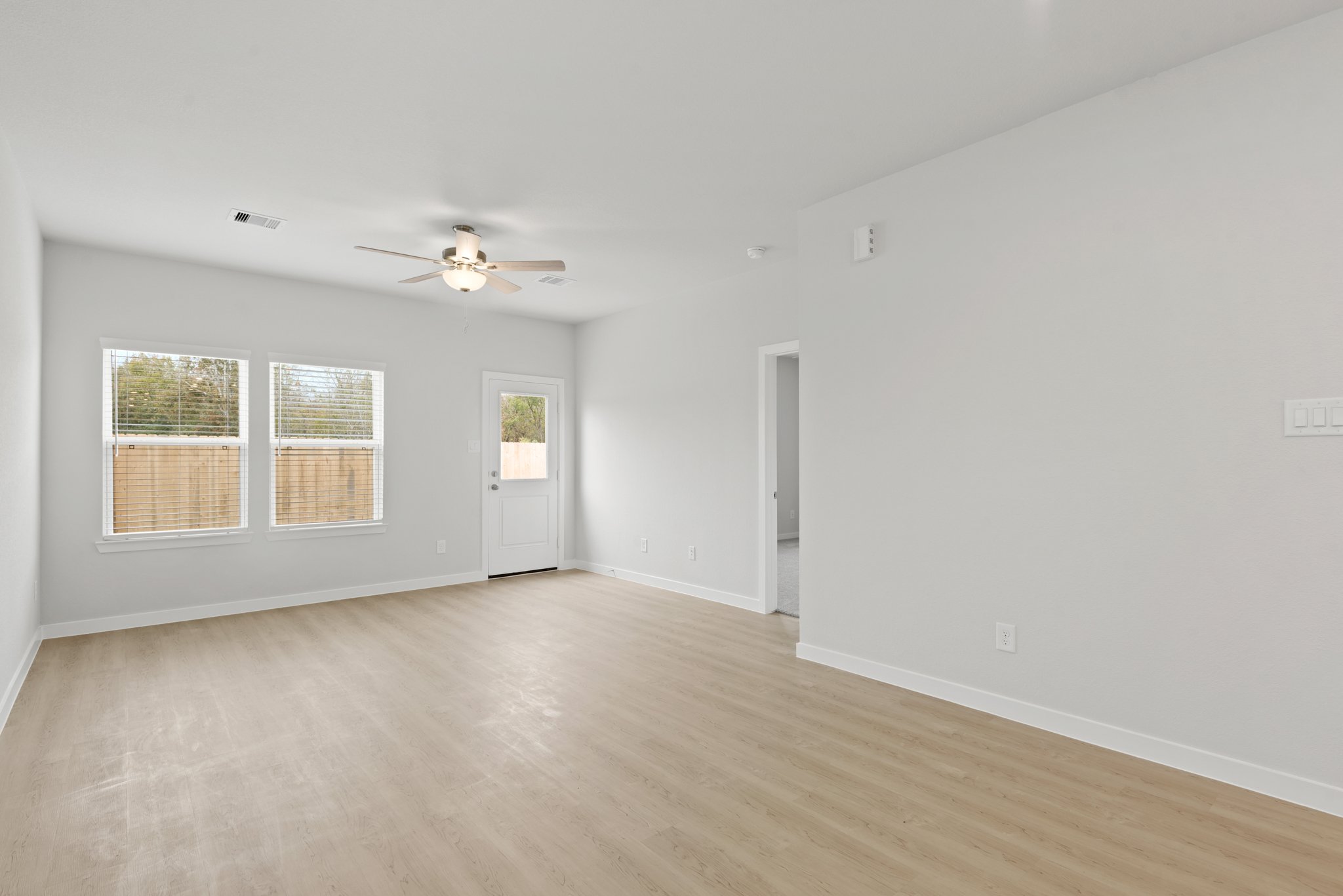 A room with a wood floor and a ceiling fan.