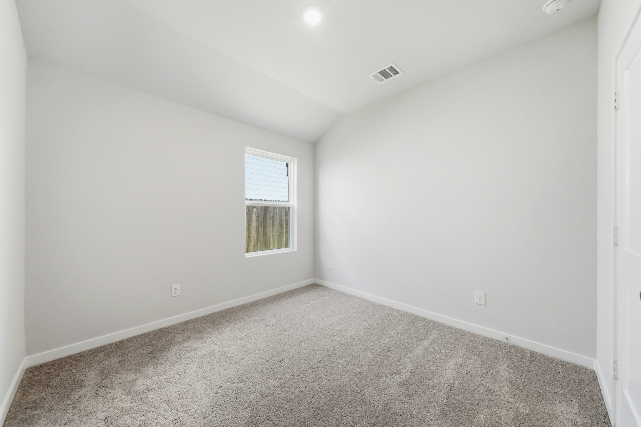A room with a carpet and windows.