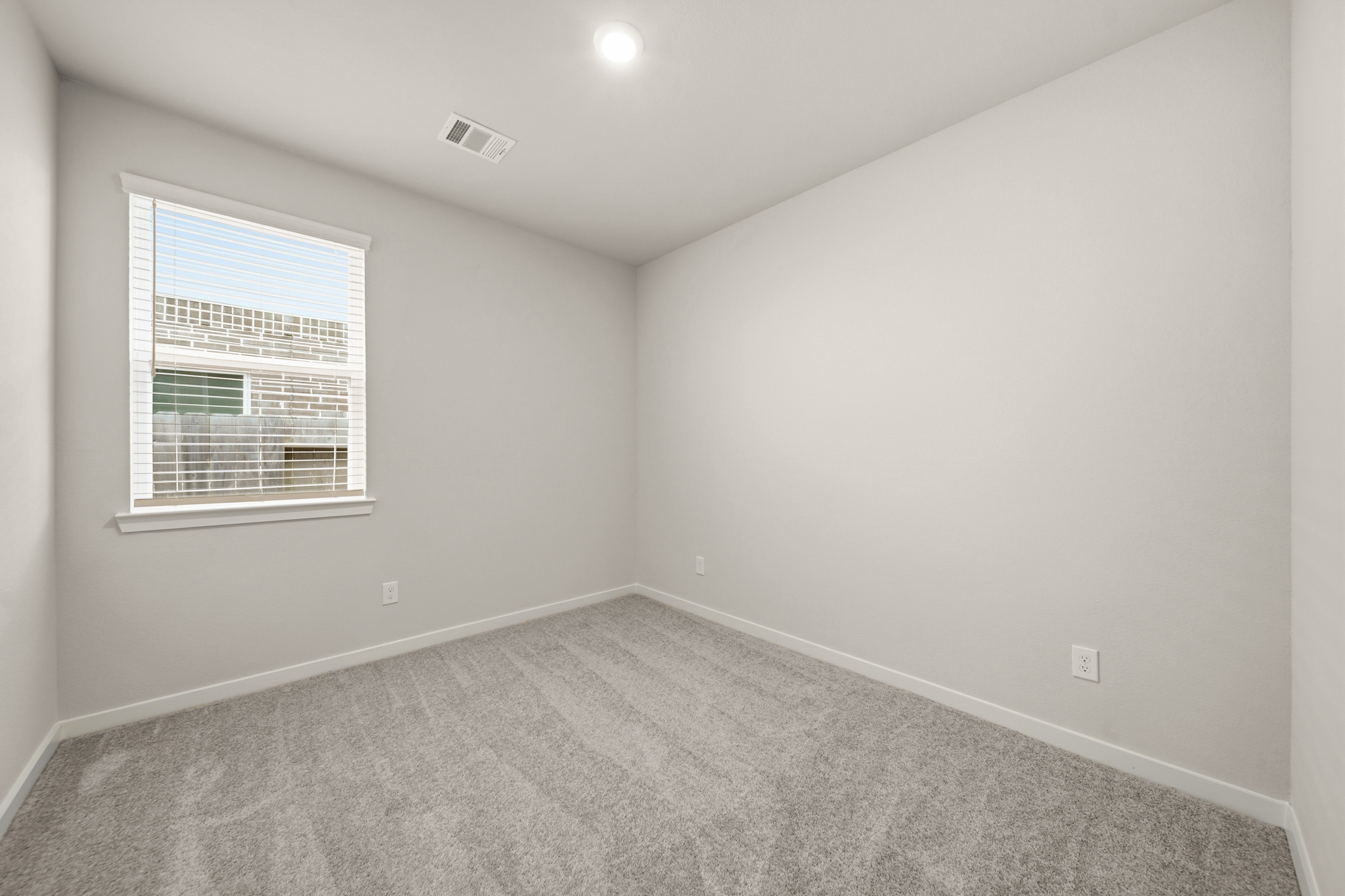 A room with a window and a carpet.