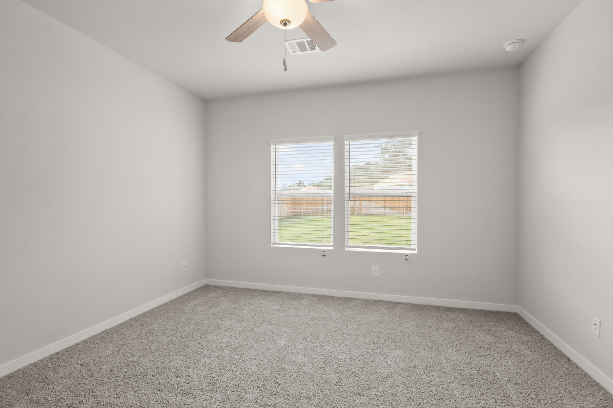 A room with a ceiling fan and a window.